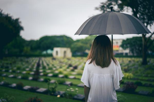 Woman at cemetery with flowers