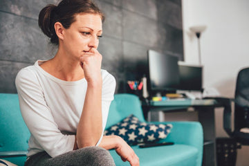 a woman sitting on a couch thinking